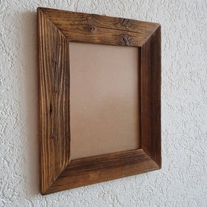 May include: A rustic wooden picture frame with a brown finish. The frame has a rectangular shape and a simple design.