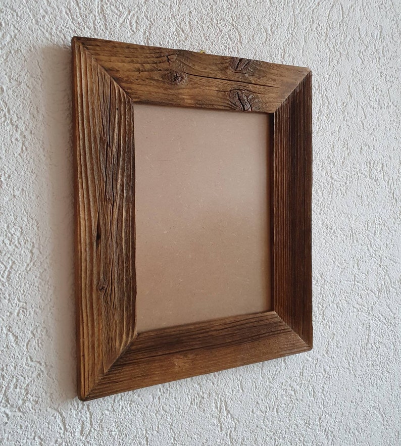 May include: A rustic wooden picture frame with a brown finish. The frame has a rectangular shape and a simple design.