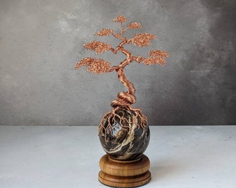 Copper wire tree on a brown opal sphere with a natural wooden sphere holder