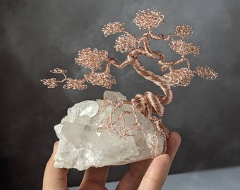 Rose gold coloured copper wire tree on a quartz base