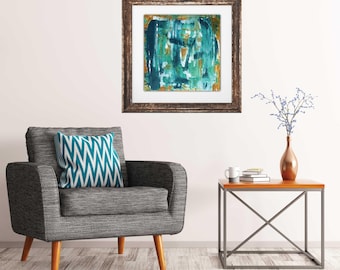 May include: A teal and gold abstract painting in a brown frame hangs on a white wall above a gray armchair with a teal and white patterned pillow. A small wooden table with a metal frame sits in front of the chair, holding a white mug and books.