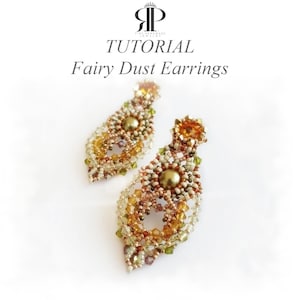 Può includere: Un paio di orecchini di perline con una perla centrale verde oliva circondata da cristalli color ambra, oro e verde chiaro a forma di goccia. Il testo TUTORIAL Fairy Dust Earrings è visualizzato sopra i gioielli su sfondo bianco.