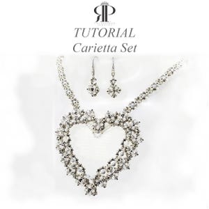 May include: A jewelry set titled TUTORIAL Carietta Set featuring a necklace with a large heart-shaped pendant and matching drop earrings. The pieces are constructed from small clear and silver-toned beads arranged in a complex, intricate pattern.