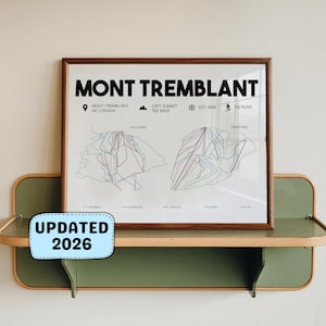 Peut inclure: Une affiche encadrée de la carte de la station de ski Mont Tremblant, avec le texte "MONT TREMBLANT" en haut. L'affiche est exposée sur une étagère verte et beige. Le texte "UPDATED 2026" est sur un autocollant bleu.