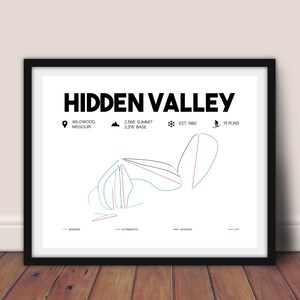 Op de afbeelding: Zwart ingelijste print van de Hidden Valley skiparkkaart. De kaart bevat de naam van het resort, de locatie in Wildwood, Missouri, de top van 782 meter en 15 pistes. De kaart toont beginner, intermediate en gevorderde pistes.