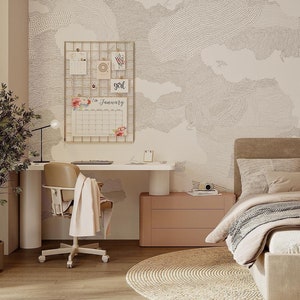 Puede incluir: Un dormitorio con un escritorio blanco, una silla marrón, una cómoda rosa, una cama con una cabecera marrón y una manta beige, y una pared con un papel tapiz estampado beige y blanco con las palabras "girl" y "January" en él.