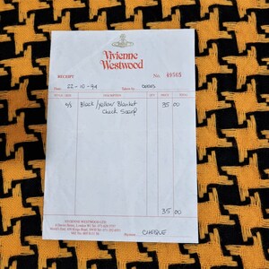 May include: A receipt from Vivienne Westwood for a black and yellow blanket check scarf. The receipt number is 49565 and the date is 22-10-94. The price of the scarf is £35.00 and the payment method is cheque.