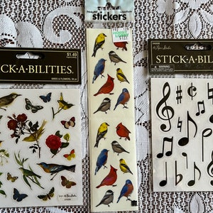 May include: Three packs of sticker sheets. The first sheet features colorful birds and flowers. The second sheet features musical notes. The third sheet features a variety of birds. All sheets are labeled "Stick-A-Bilities".