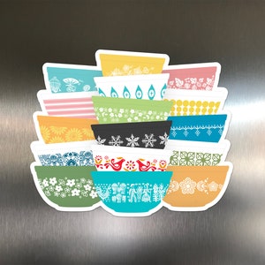 May include: A stack of 14 colorful vintage-style mixing bowls with various patterns, including snowflakes, flowers, and geometric designs.