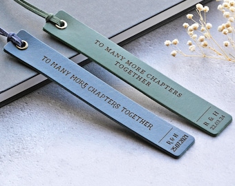 May include: Two leather bookmarks, one blue and one green, with the text "TO MANY MORE CHAPTERS TOGETHER." The blue bookmark has "R & H 25.07.2021" and the green bookmark has "R & H 22.03.24". Both have a cord attached.
