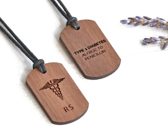 May include: Two wooden medical alert tags on a black cord necklace. One tag has a medical symbol and the initials "RS". The other tag reads "Type 1 Diabetes Allergic to Penicillin".
