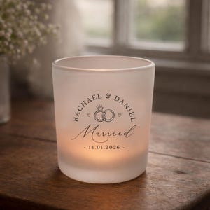 May include: Frosted glass candle holder with the names "Rachael & Daniel" and the word "Married" in elegant script. The date "14.01.2026" is printed below. The candle holder features a wedding ring design.