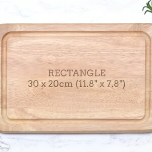 K&ouml;nnte beinhalten: Rechteckiges Schneidebrett aus hellem Holz mit vertieftem Rand. Der Text "RECTANGLE" ist eingraviert, zusammen mit den Ma&szlig;en: 30 x 20 cm (11,8" x 7,8").