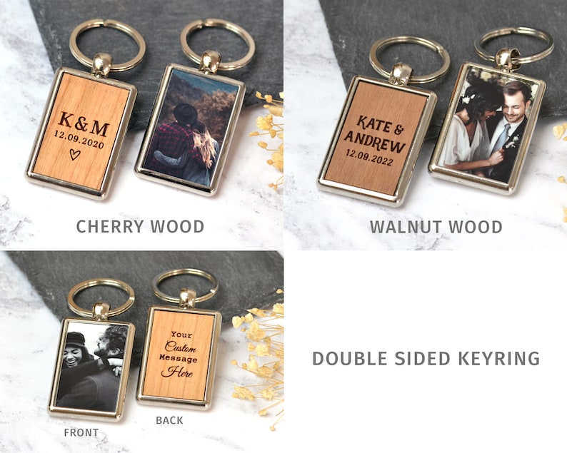 Puede incluir: Llaveros rectangulares de doble cara con marcos de metal plateado. Un lado presenta incrustaciones de madera con texto grabado como K&M 12.09.2020 o Kate & Andrew 12.09.2022, mientras que el otro lado muestra una fotograf&iacute;a impresa. Incluye anilla.