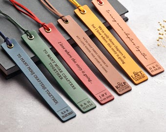 May include: A collection of six leather bookmarks in various colors, each with a different quote and personalized details. The bookmarks have a loop at the top with a matching cord. The text includes dates and initials.