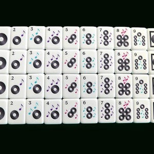 Peut inclure: Un ensemble de tuiles de Mahjong blanches avec des motifs de notes de musique et de disques noirs. Les tuiles sont dispos&eacute;es en rang&eacute;es et en colonnes, avec les chiffres 1 &agrave; 9 sur chaque rang&eacute;e. Les notes de musique sont de couleurs vari&eacute;es.