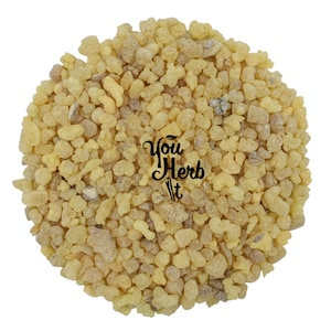 Puede incluir: Una vista cercana de un montón de resina de incienso de color amarillo pálido. La resina está en pequeños trozos irregulares. La imagen se toma desde arriba.