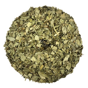 May include: A close-up of a pile of dried green leaves. The leaves are loose and appear to be chopped or shredded. The leaves are a light green colour and have a slightly brown hue. The leaves are arranged in a circular shape.