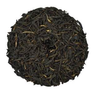 May include: Loose black tea leaves with a golden hue. The tea leaves are dried and ready to be brewed.