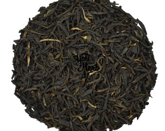 May include: Loose black tea leaves with a golden hue. The tea leaves are dried and ready to be brewed.