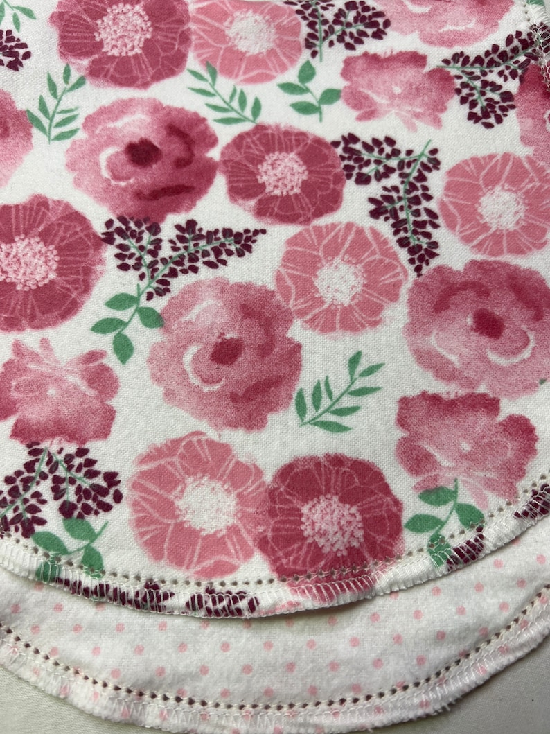 Puede incluir: Dos capas de tela con un patr&oacute;n floral rosa. La capa superior tiene un fondo blanco con flores rosas y hojas verdes. La capa inferior tiene un fondo blanco con peque&ntilde;os puntos rosas.