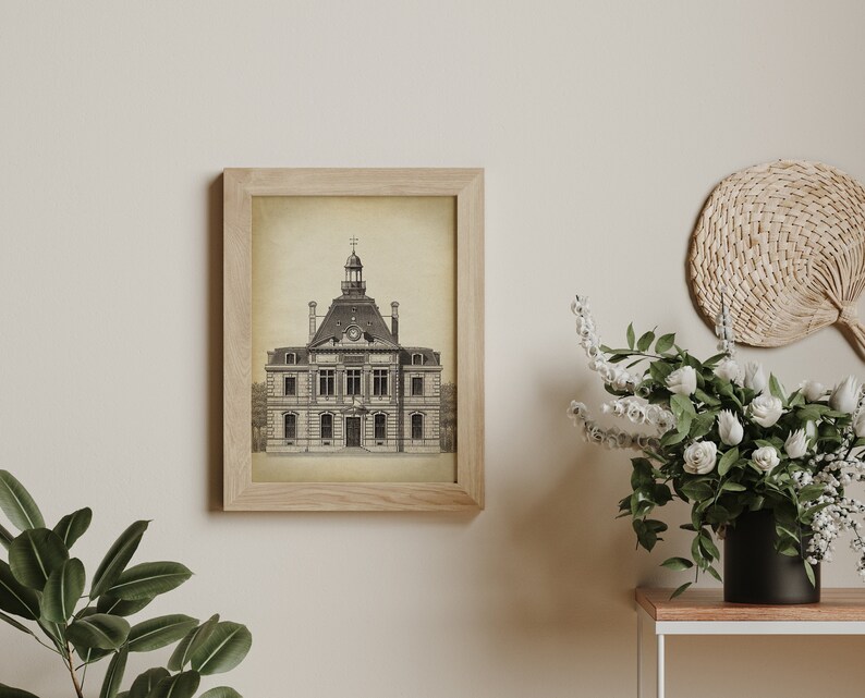 Op de afbeelding: Een zwart-witte illustratie van een gebouw met een klokkentoren, ingelijst in een licht houten frame. De illustratie is op een beige achtergrond.