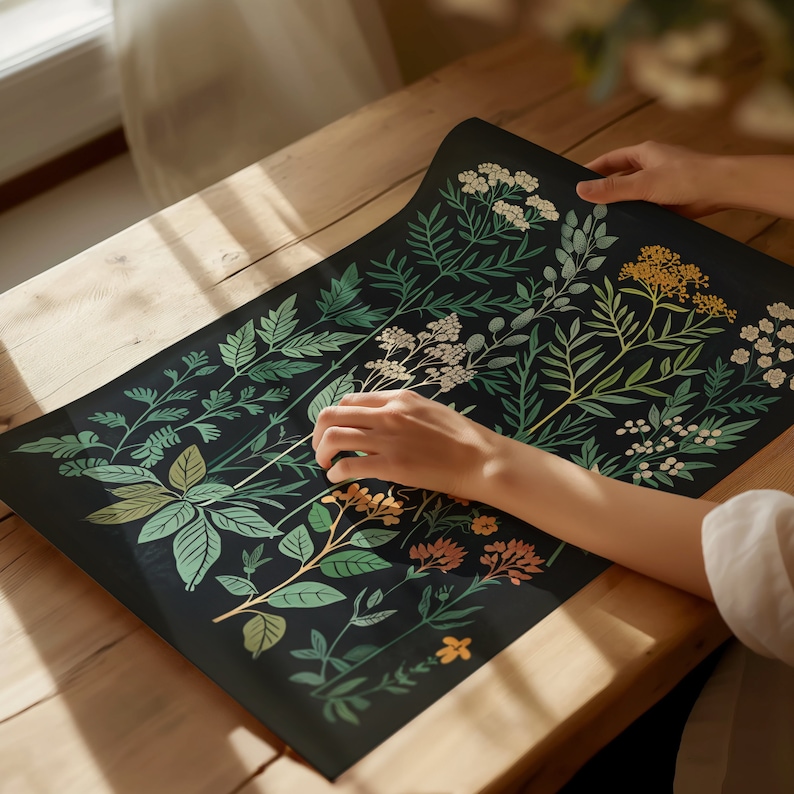 May include: A black background with a botanical illustration of various green leaves and flowers in shades of yellow, white, and orange. The illustration is printed on a flat surface.