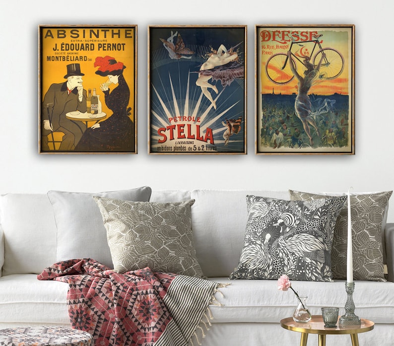 Puede incluir: Tres anuncios vintage enmarcados en oro. El anuncio de la izquierda es para Absenta, el anuncio del medio es para Stella Petroleum, y el anuncio de la derecha es para Deesse, una marca de bicicletas.