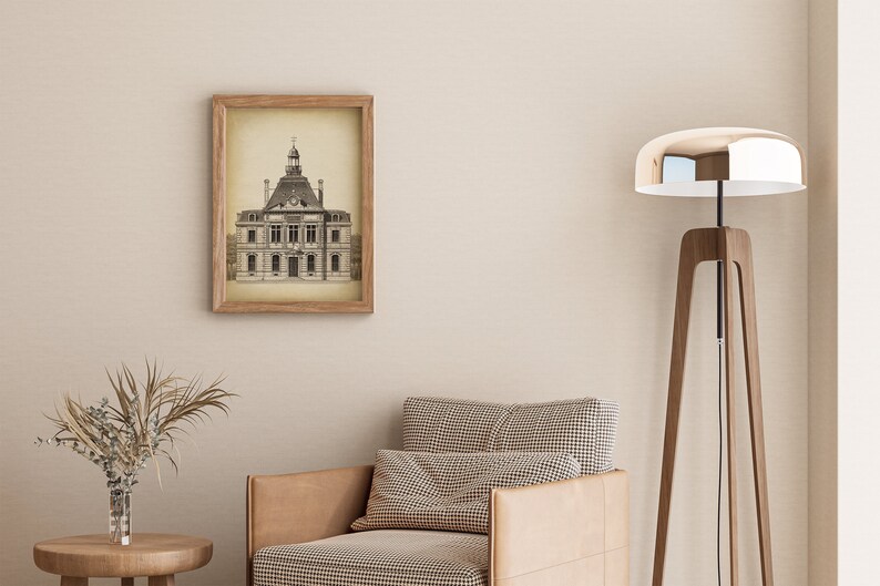 Op de afbeelding: Een ingelijste zwart-witprint van een oud gebouw met een klokkentoren. De print hangt aan een beige muur boven een bruine fauteuil met een geruit patroon. Een hoge houten staande lamp met een zilveren lampenkap staat in de hoek van de kamer.