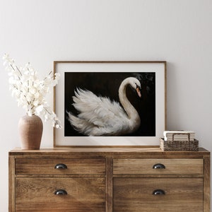 May include: A framed painting of a white swan with its head turned to the side, against a dark background.