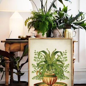 May include: A framed botanical illustration of a fern plant growing in a vintage teacup and saucer. The teacup is decorated with green, orange, and yellow stripes and a white polka dot pattern. The saucer is green with a yellow and orange stripe pattern.