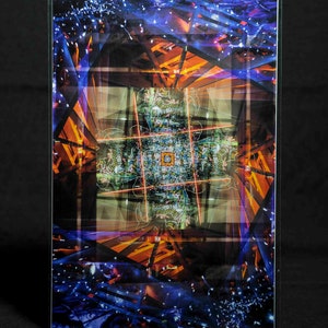 May include: A colorful abstract image with a geometric pattern of overlapping lines and shapes. The image is dominated by shades of blue, orange, and green, with a central focus on a smaller, more intricate pattern.