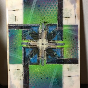 May include: Abstract art painting on a wooden canvas. The painting features a green, blue, and purple colour scheme with geometric shapes and a grid pattern. The painting has a textured, layered look.