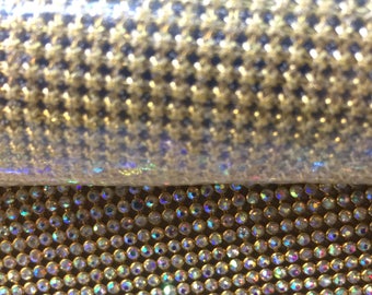 May include: A roll of iridescent gold rhinestone mesh fabric. The mesh is made of small, round rhinestones that are set in a grid pattern.