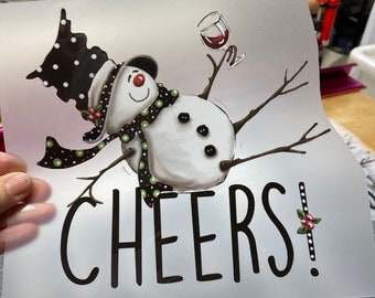 May include: A white snowman with a black and white polka dot hat and a green scarf is holding a glass of red wine. The snowman is on a white background with the word "CHEERS!" in black text.