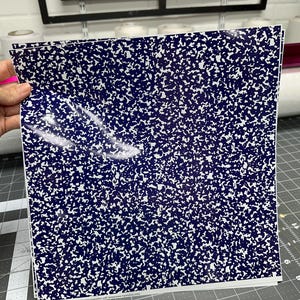 May include: A stack of blue and white patterned vinyl sheets. The pattern resembles the paper of a composition notebook.