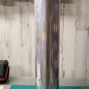 May include: A roll of silver holographic vinyl with a textured surface.