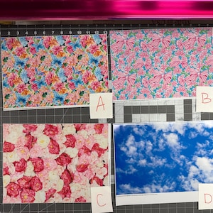 May include: Four patterned papers are displayed. One features butterflies and flowers in pink, blue, and yellow. Another has pink bows on a turquoise background. A third showcases pink and white roses. The last shows a blue sky with clouds.
