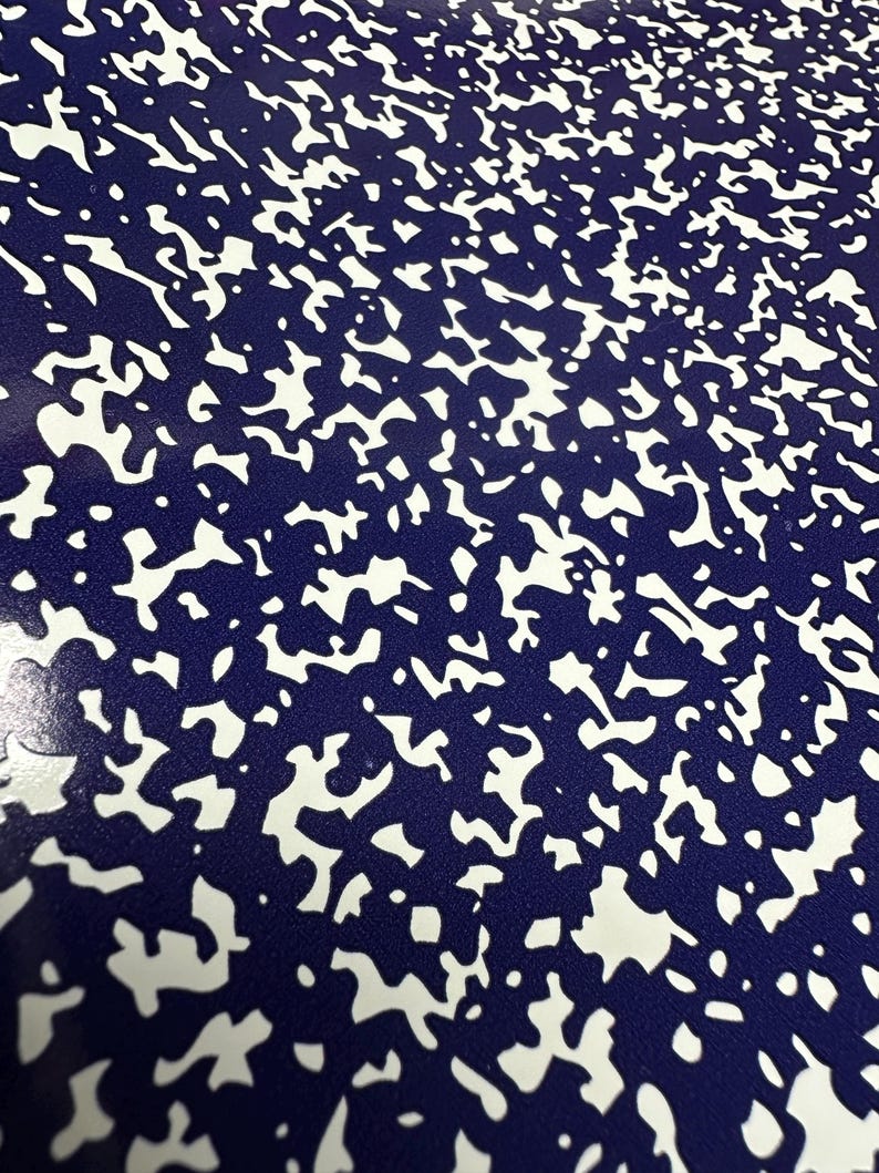 May include: A close-up of a blue and white speckled surface. The surface has a random pattern of white spots on a dark blue background.
