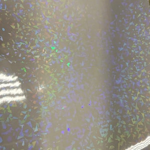 May include: A sheet of iridescent holographic vinyl with a white background and a pattern of small, randomly placed, iridescent triangles.