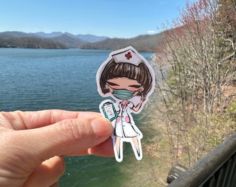 Puede incluir: Una pegatina con una enfermera de dibujos animados que lleva una mascarilla y un uniforme blanco con detalles en rosa. La enfermera sostiene una carpeta y hace el signo de la paz. El fondo muestra un lago y montañas.