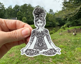 May include: Black and white sticker of a woman in a yoga pose with intricate floral patterns covering her body. The sticker is on a white background.