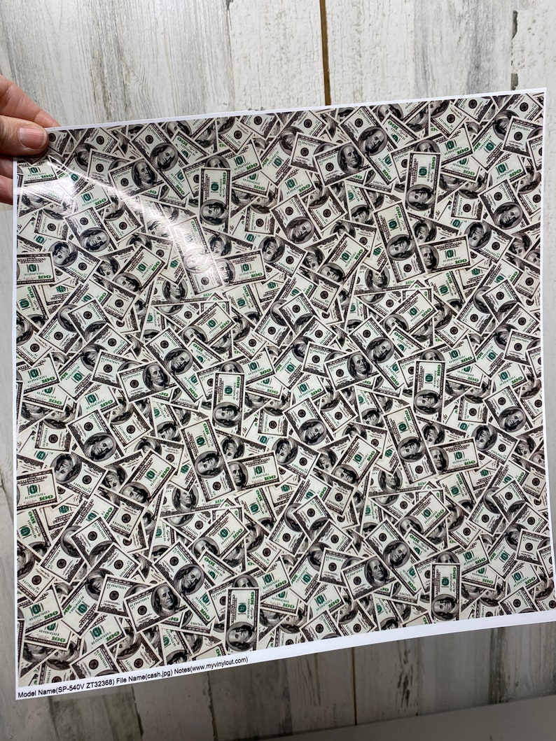 May include: A print featuring a dense pattern of United States one hundred dollar bills. The bills are in various orientations, creating a textured, money-themed design. The print includes the text "Model Name (SP-540V ZT32368) File Name(cash.jpg) Notes(www.myvinylcut.com)".