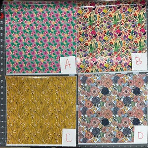 May include: Four sheets of patterned paper are displayed. The patterns include a pink floral design, a colorful floral arrangement, a mustard yellow pattern with black branches, and a floral and cactus design. Each sheet is labeled with a letter.