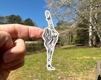May include: A black and white sticker of a woman in a yoga pose. The woman is adorned with intricate floral patterns.