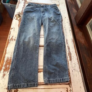 May include: A pair of blue denim jeans with a straight leg fit. The jeans have a light wash and are made of a soft, comfortable fabric.