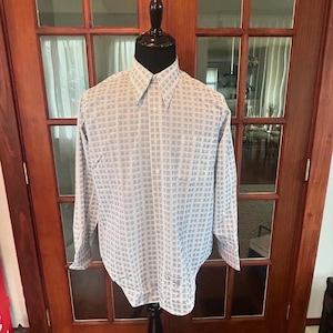 May include: A white long-sleeve button-down shirt with a small black geometric pattern.