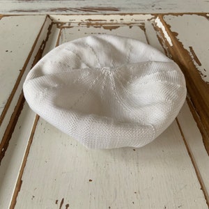 Puede incluir: Un gorro blanco de punto con un patrón texturizado.