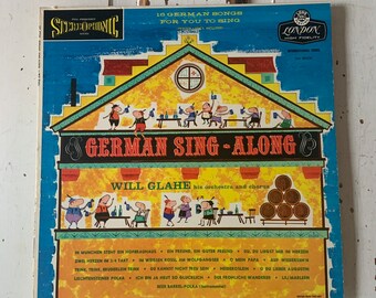May include: A vintage vinyl record album cover featuring a cartoon illustration of a German-style building with people drinking and singing. The album title is "German Sing-Along" with the artist "Will Glahe" and his orchestra and chorus. The album cover is blue, yellow, and red with a London Records label.