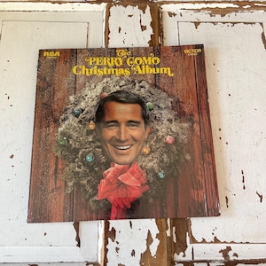 Puede incluir: Una portada de álbum de vinilo vintage con Perry Como y una corona de Navidad. El título del álbum es "The Perry Como Christmas Album" con el logotipo de RCA Victor.